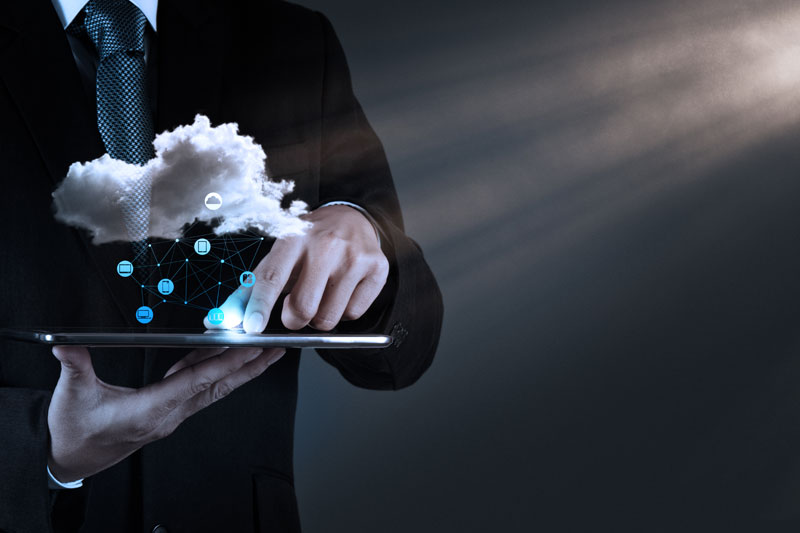 man holding computer and phone connected with cloud